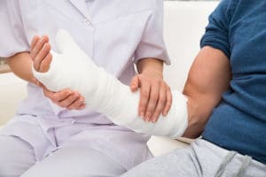 Female Doctor Holding Fractured Hand Of A Patient