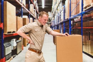 Worker feeling back pain in warehouse