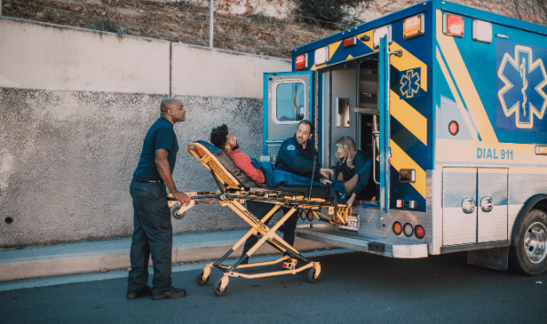 Paramedics loading patient into back of ambulance